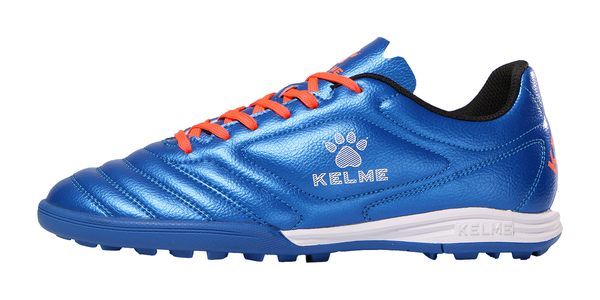 Kelme royal blue TF soccer shoe with orange laces, white midsole, paw logo