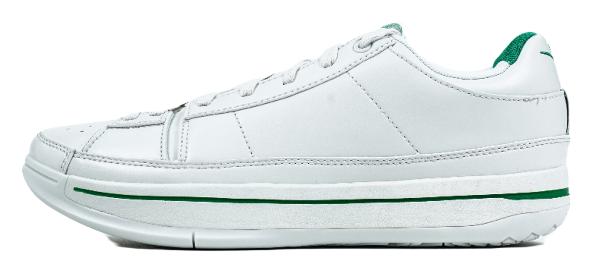 White low-top basketball shoes with green stripe trim and side logo detail