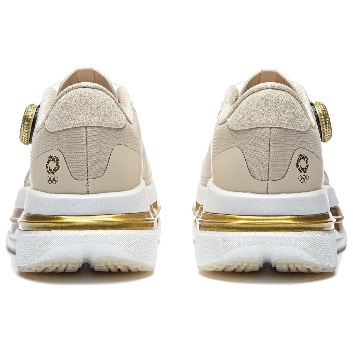 Women’s running shoes heel view in light beige with gold emblem and cushioned sole.