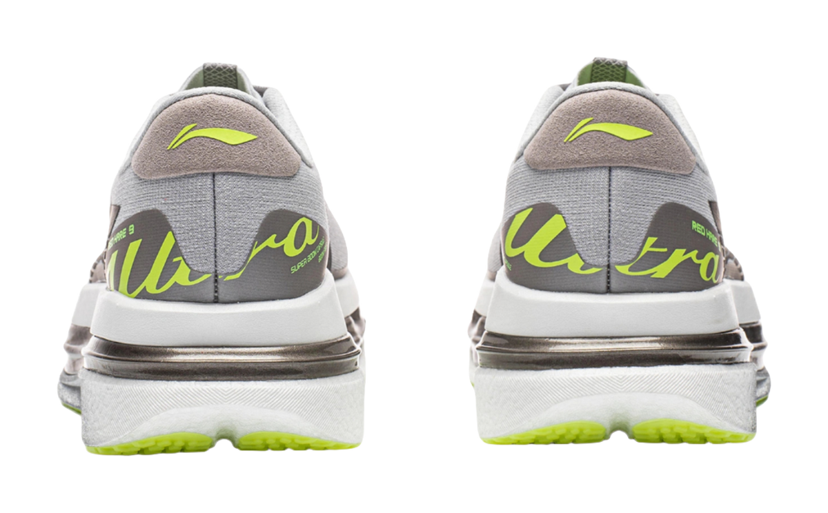 Men's running shoes pair showing heel, gray uppers with lime trim and thick silver sole