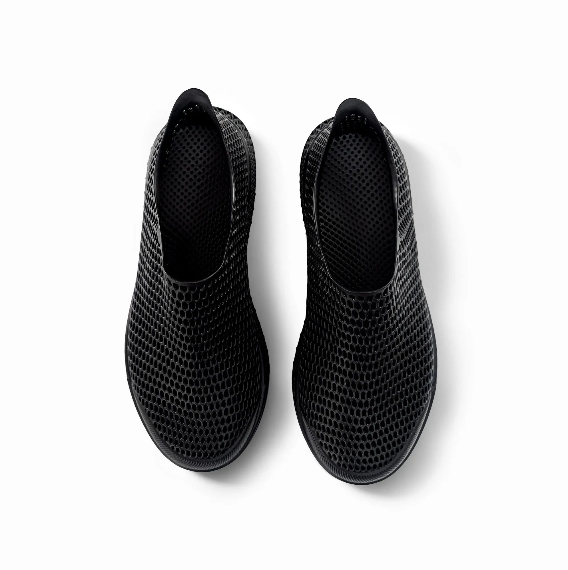 Black 3D-printed slip-on sneakers with perforated mesh upper and rounded toe