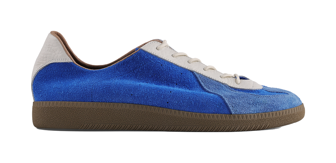 Blue low-top training sneaker with white laces and brown textured sole, profile.