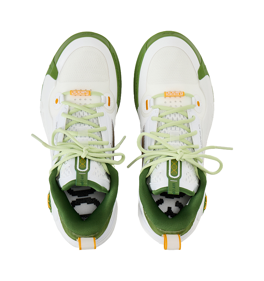 Pair of white low-top basketball shoes with light green laces and green inner lining.