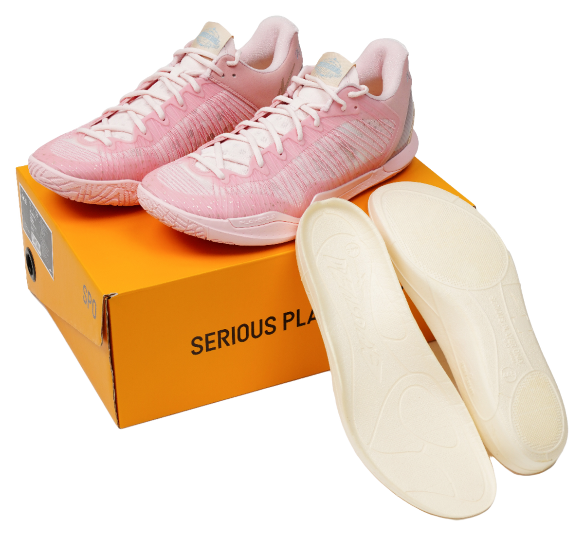 Pink basketball shoes with matching insoles, resting on an orange logo box