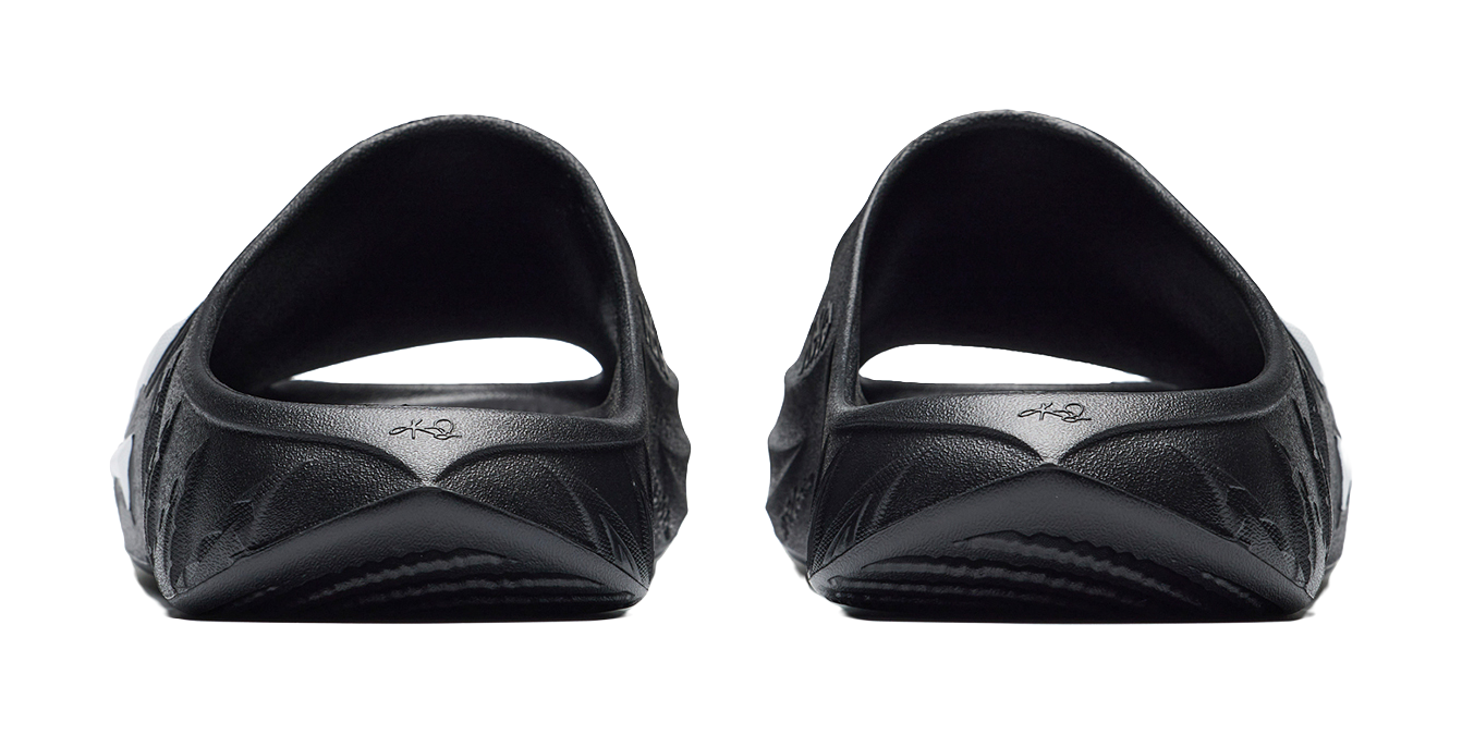 Men's black slide slippers, heel view with molded cushioning and subtle brand marks