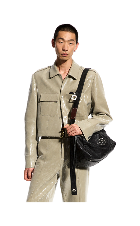 Black pleated leather crossbody bag with flap and front logo emblem.