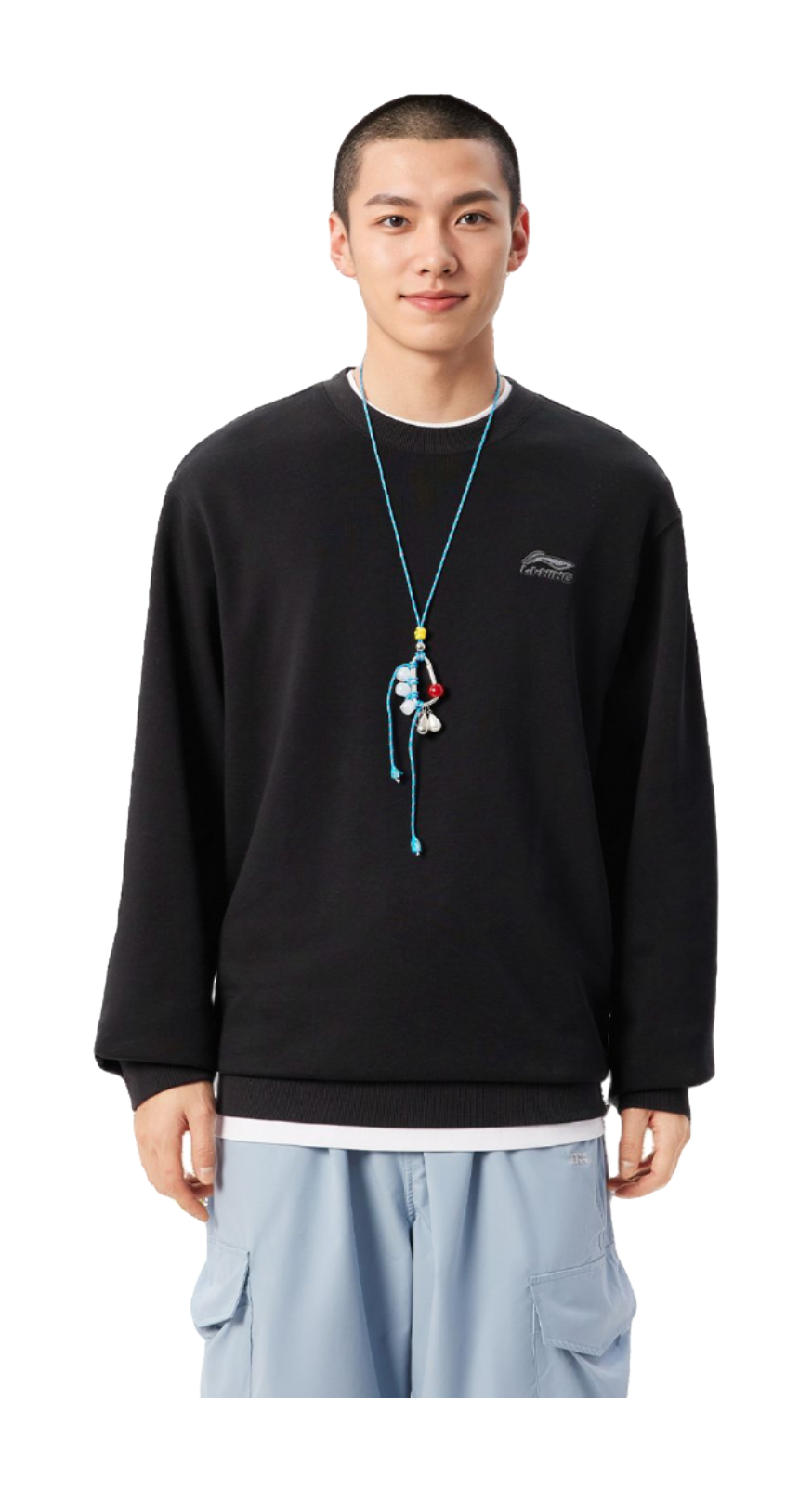 Black crewneck sweatshirt on model, long sleeves with small chest logo; ribbed hem.