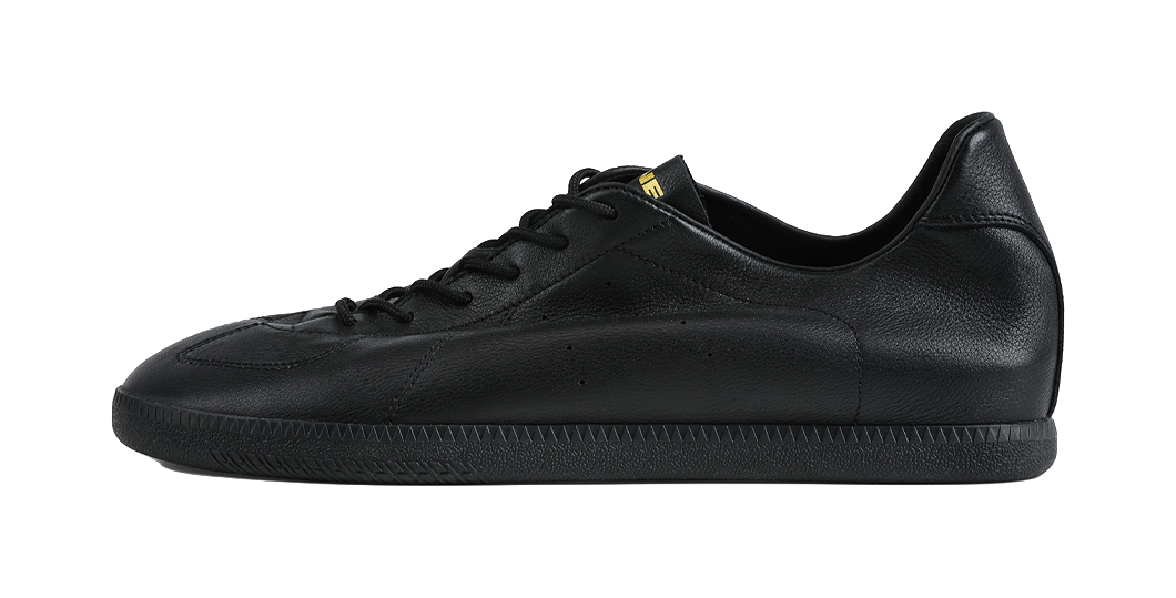 Black low-top training sneaker with black laces and smooth leather upper