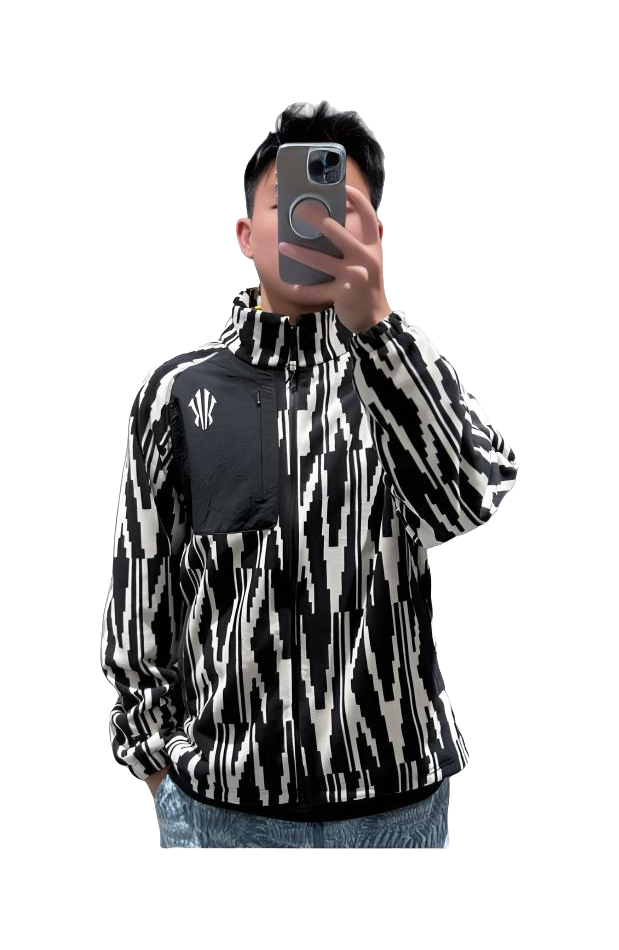 Unisex zip-up sweatshirt jacket worn; black-and-white all-over pattern with small chest logo.
