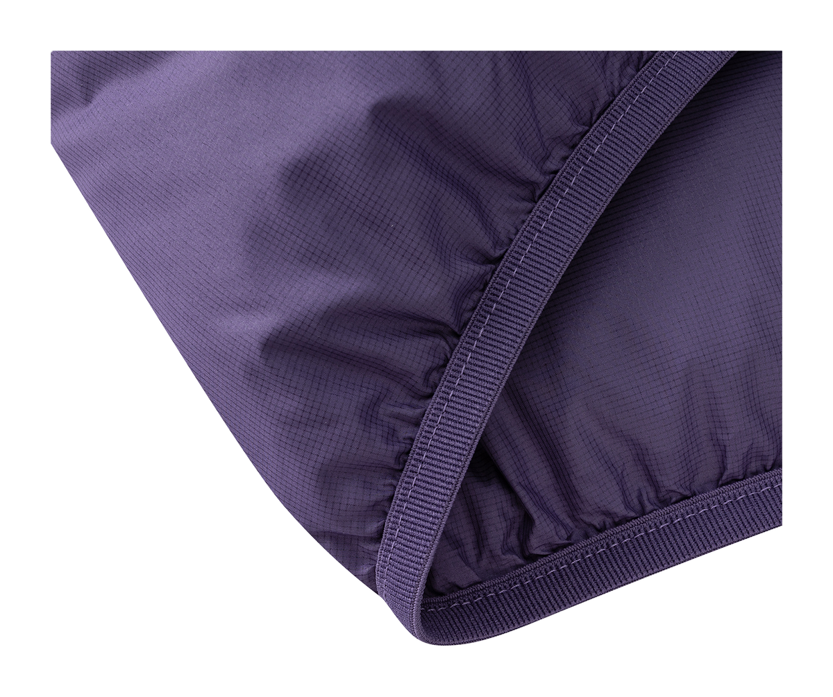 Purple puffer jacket sleeve cuff close-up with elastic seam and quilted panels