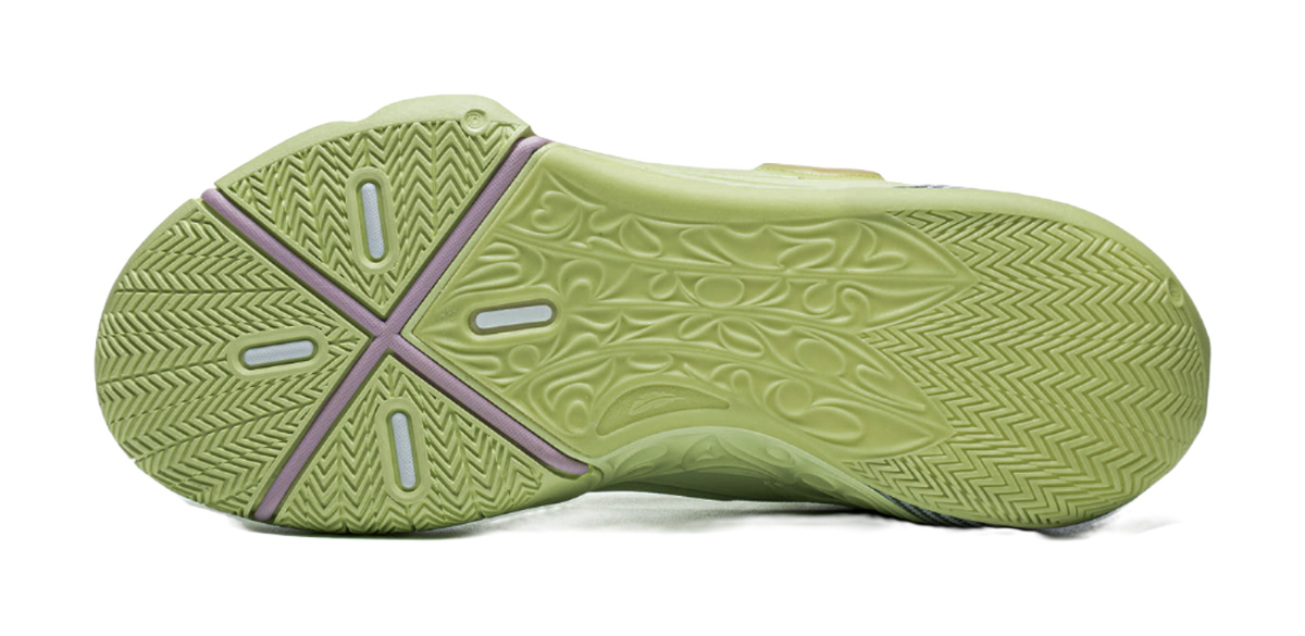 Green basketball shoe outsole view with herringbone traction pattern and purple heel tab