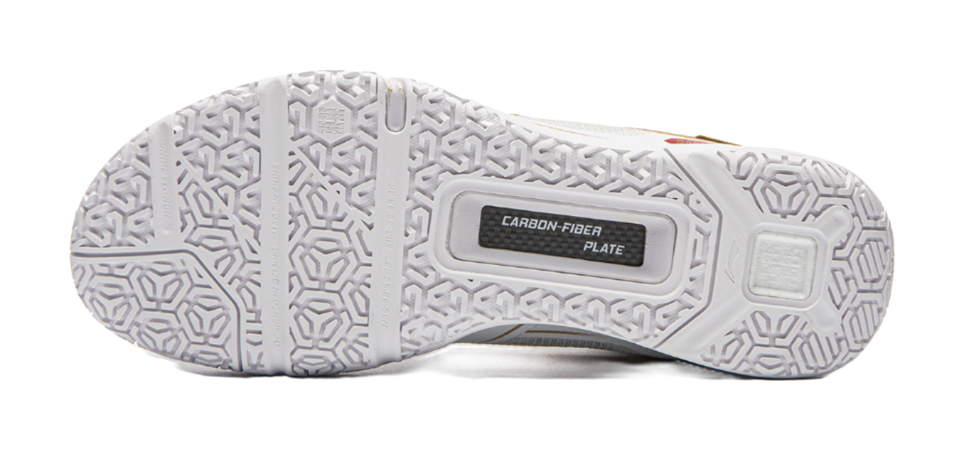 Outsole of white badminton shoe with textured grip pattern and carbon fiber plate label