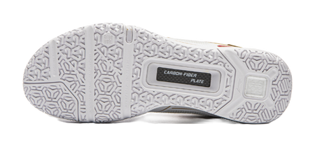 Outsole of white badminton shoe with textured grip pattern and carbon fiber plate label