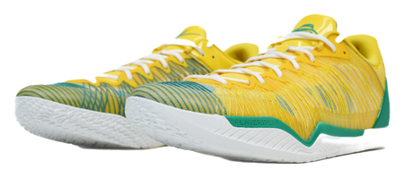 Pair of yellow basketball shoes with green accents and white textured outsoles