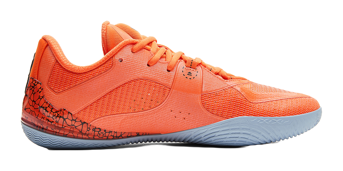 Orange basketball shoe, side view, textured upper and blue-gray rubber sole