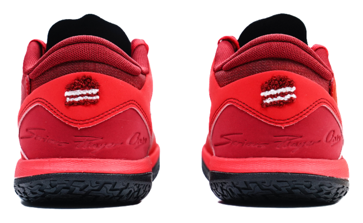 Red low-top basketball shoes, heel view with logo detail and black outsole
