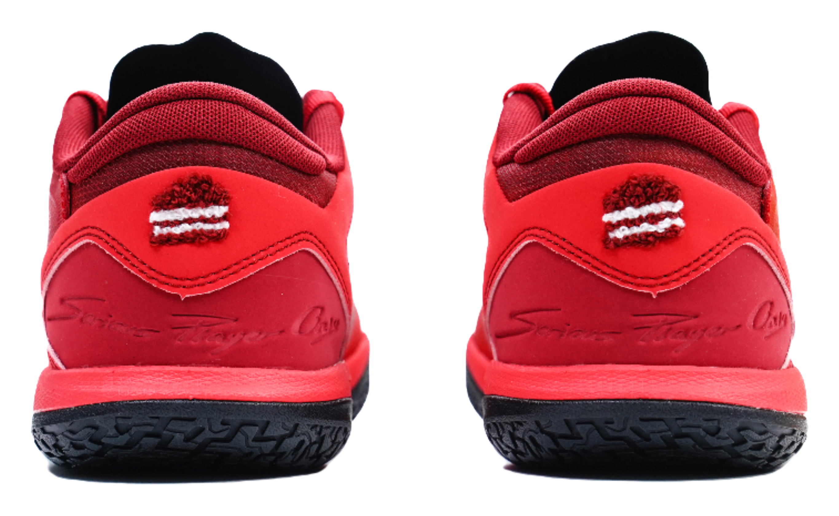 Red low-top basketball shoes, heel view with logo detail and black outsole