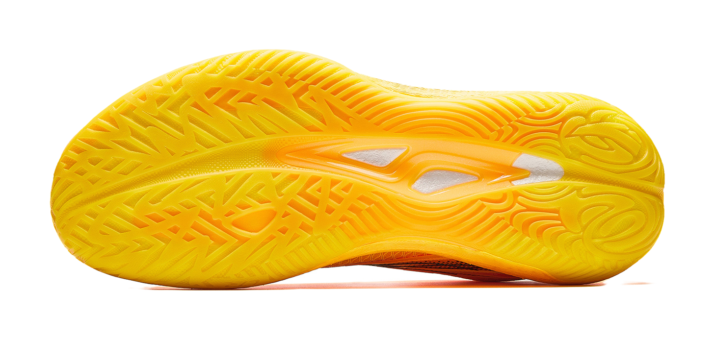 Yellow basketball shoe outsole with patterned tread and orange midfoot graphic