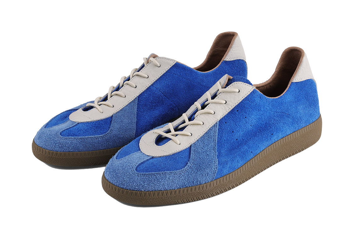 Front three-quarter view of blue low-top sneakers with white lace panels and brown sole.