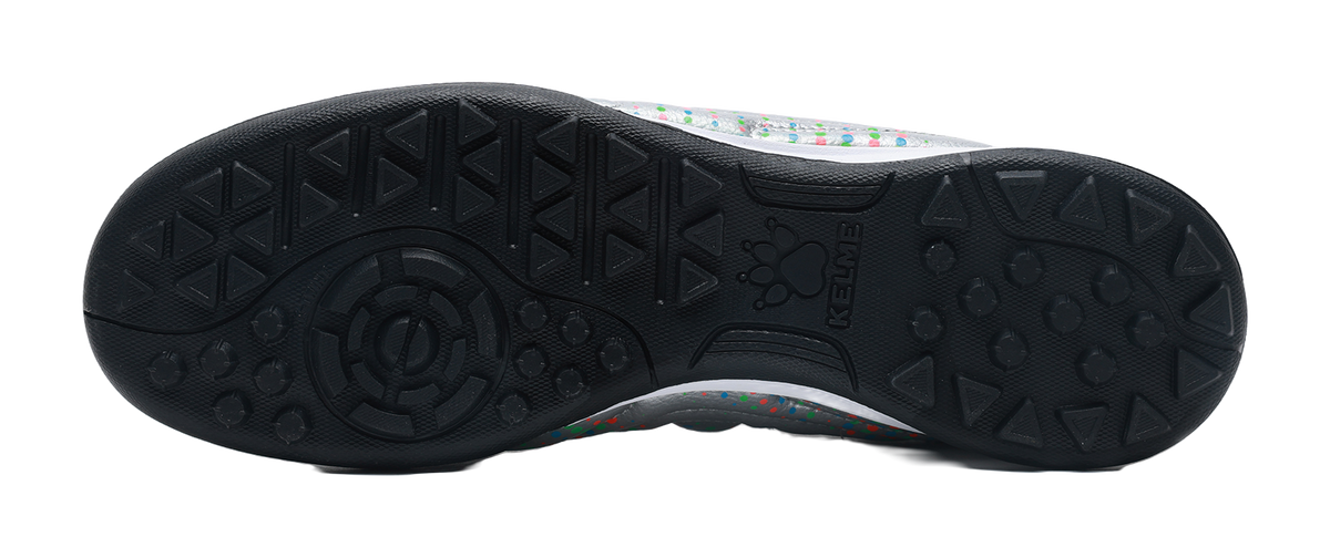 Black TF turf outsole with textured studs under silver shoe upper, KELME
