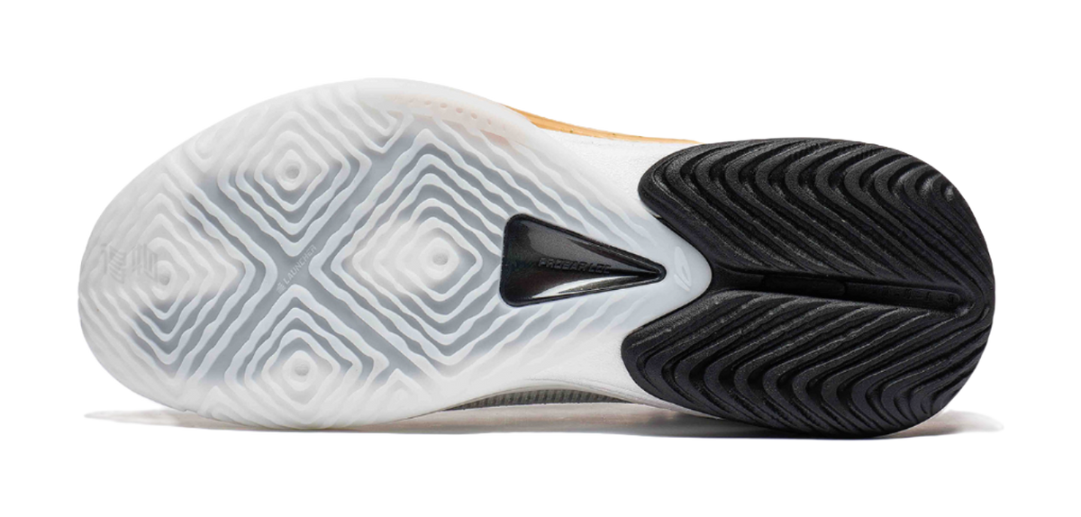 Basketball shoe outsole in white and black with patterned traction tread