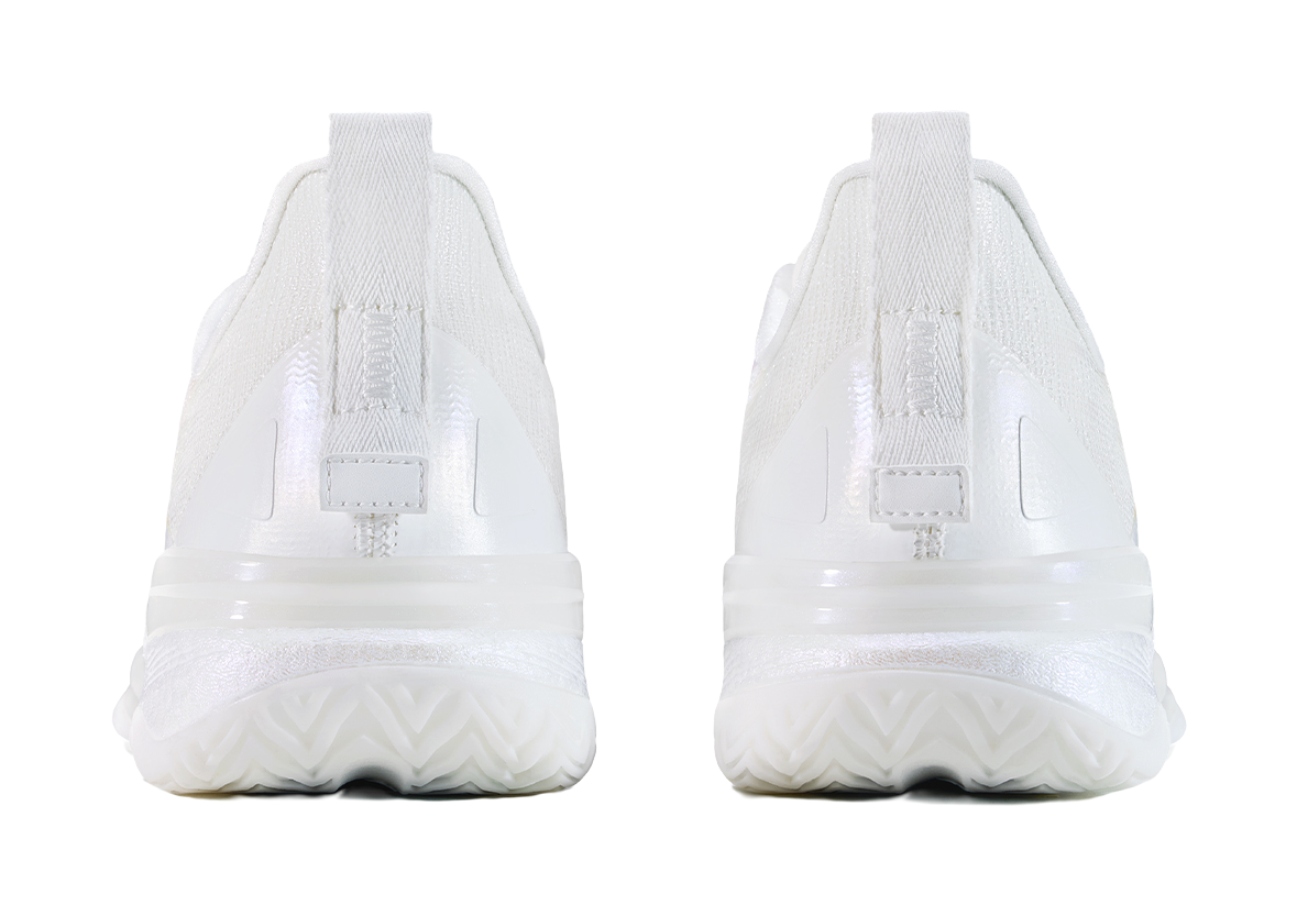 White low top basketball shoes, rear view with cushioned midsole and heel pull tab.