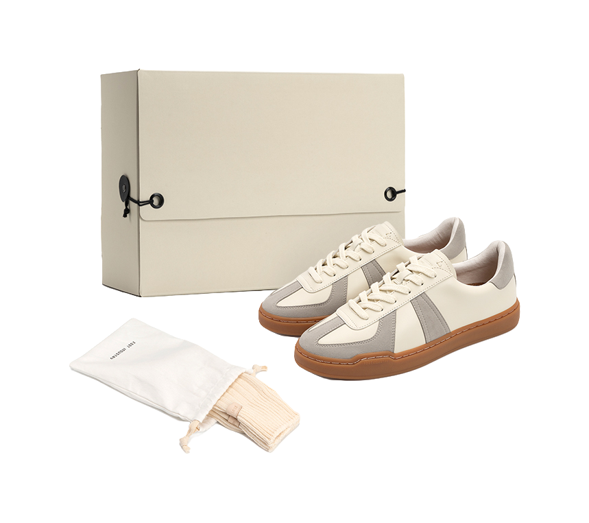 Low-top skate shoes with off-white uppers, gray panels, tan gum sole and white laces