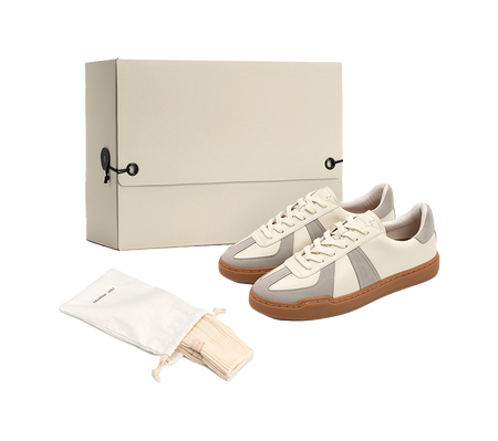 Low-top skate shoes with off-white uppers, gray panels, tan gum sole and white laces