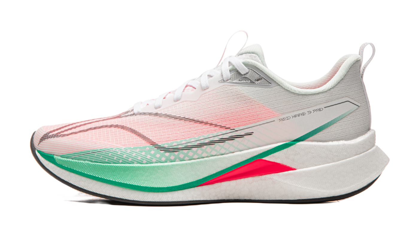Running shoe with white base and pink patterned upper, green stripe trim, red accent on midsole