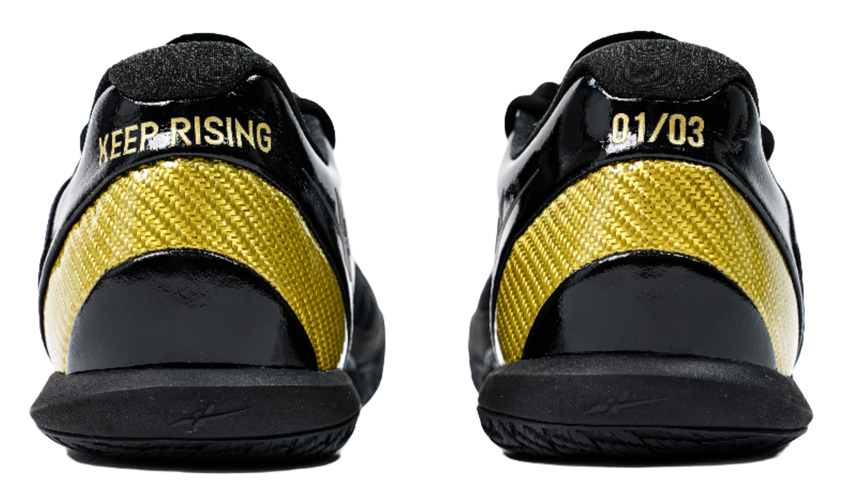 Black low-cut basketball shoes with yellow mesh panels and heel text detail