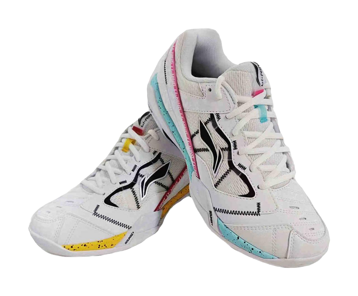 Men's white badminton shoe pair with black panels, teal sole edge, pink trim