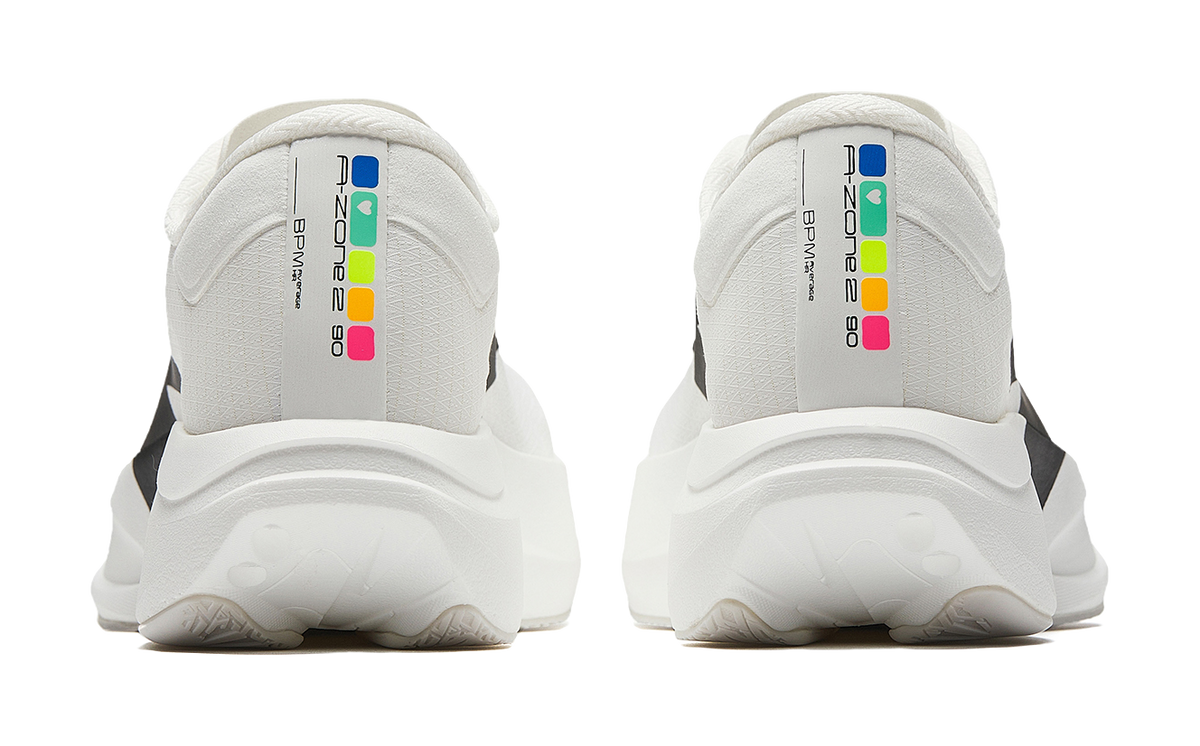 Pair of white running shoes with back heel tabs and colorful logo labels.