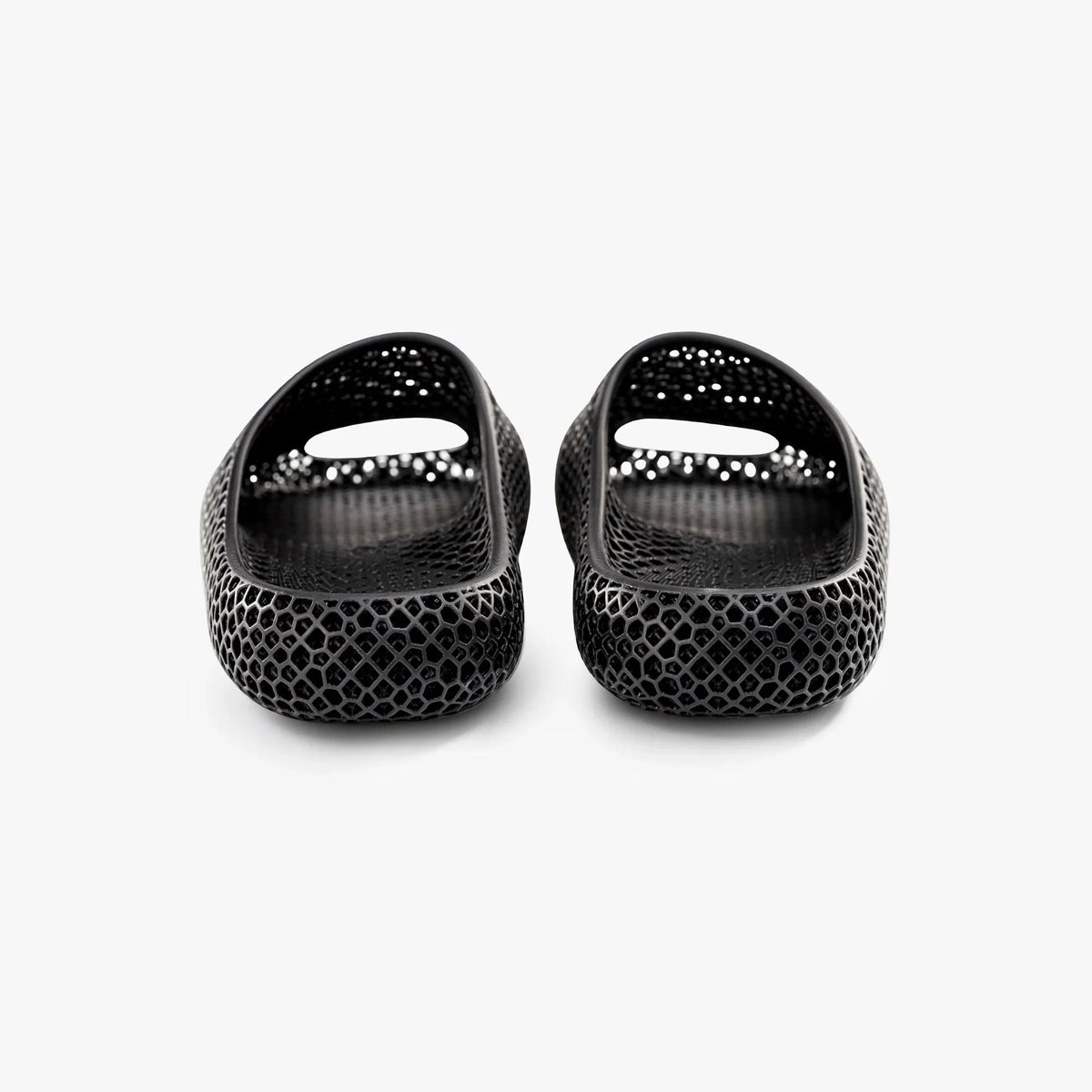 Black 3D-printed slip-on slippers, rear view, glossy textured honeycomb and heel cutouts