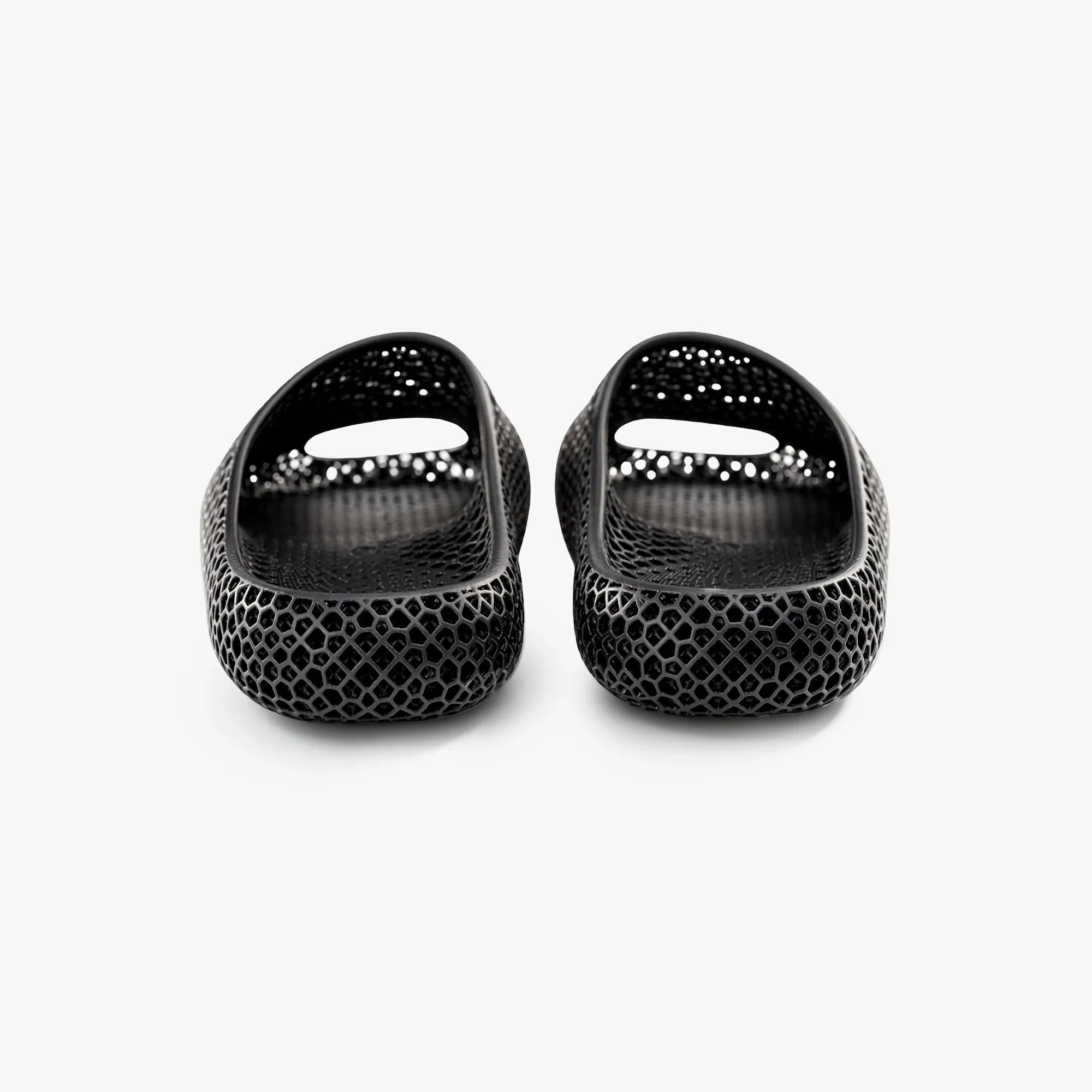 Black 3D-printed slip-on slippers, rear view, glossy textured honeycomb and heel cutouts