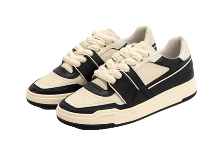 Pair of ecru low-top skate shoes with black straps and lace-up styling