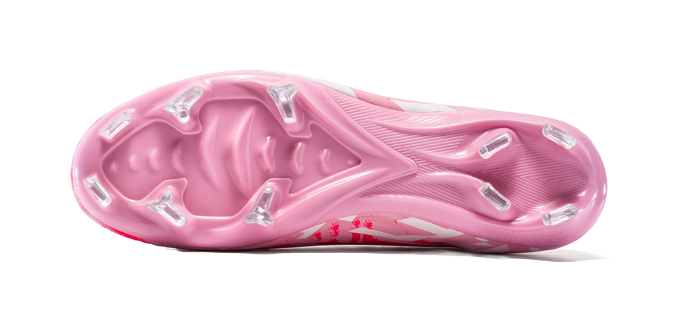 Pink firm-ground cleat outsole with molded studs and patterned heel