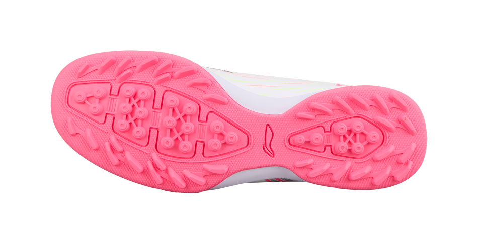 Pink rubber turf outsole with stud pattern, underside view of youth soccer shoe