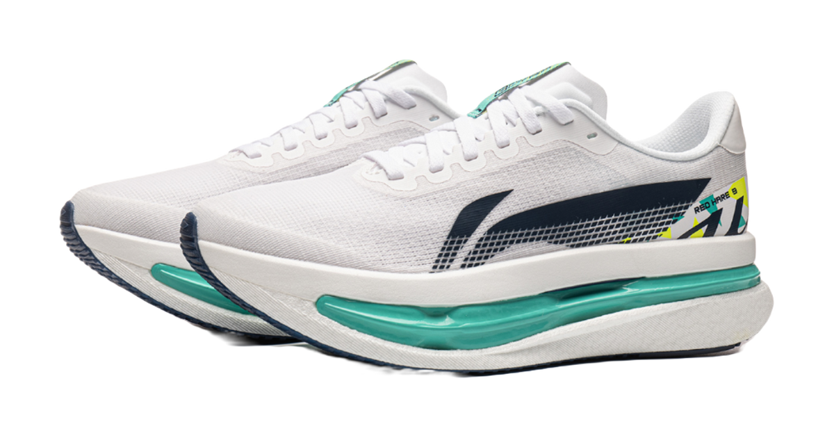 White knit running shoe with navy heel detail and teal midsole, side profile