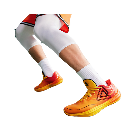 Basketball shoe on foot with orange/yellow upper and red heel collar logo