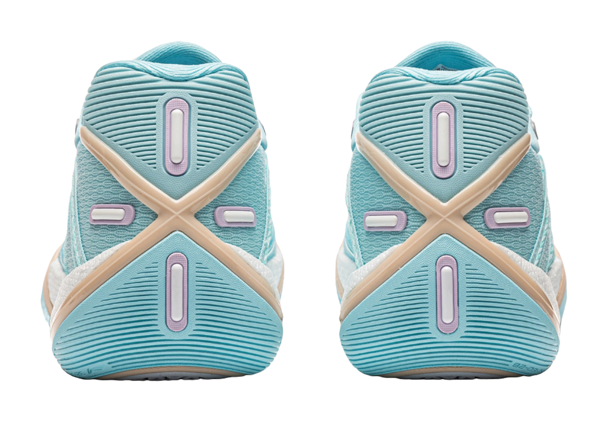 Light blue low basketball shoe heel view with striped tread and pink accent panels
