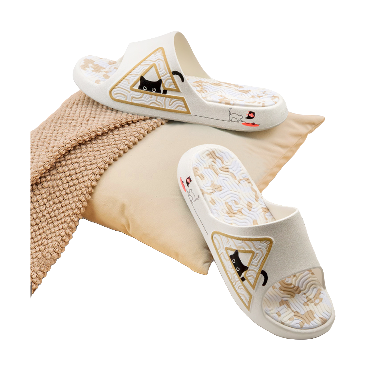 White slide sandal resting on fabric, with triangular cat graphic on the strap