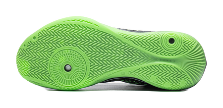 Underside sole of black and neon green low basketball shoe with green traction tread pattern