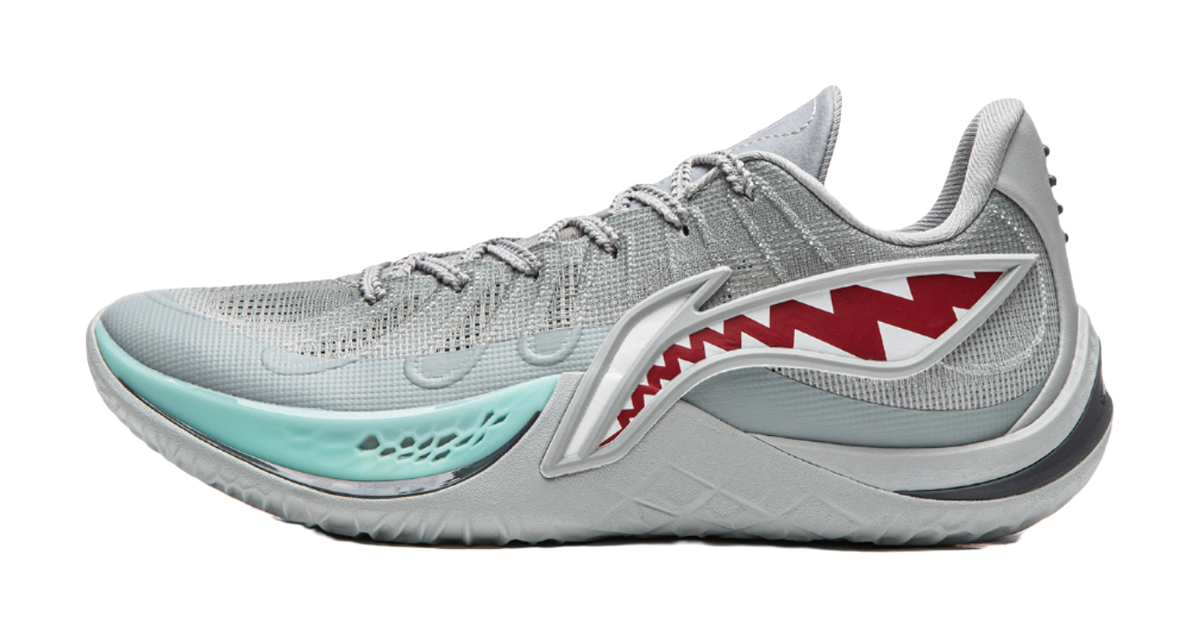 Gray basketball shoe with teal sole and red shark graphic on side