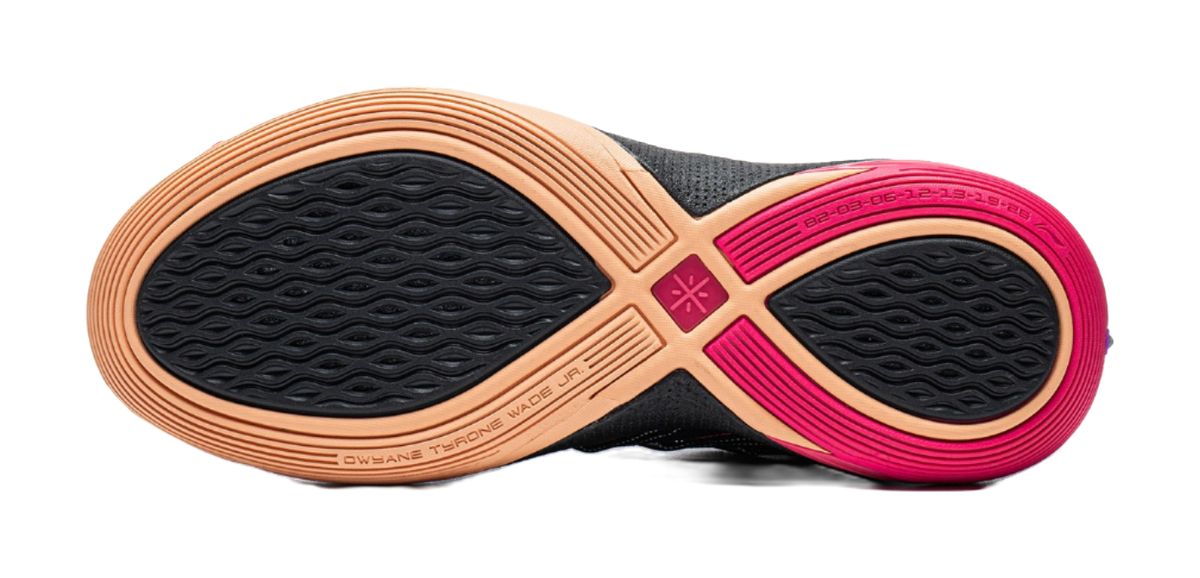 Low basketball shoe outsole view: textured black tread with gum and pink rubber areas.