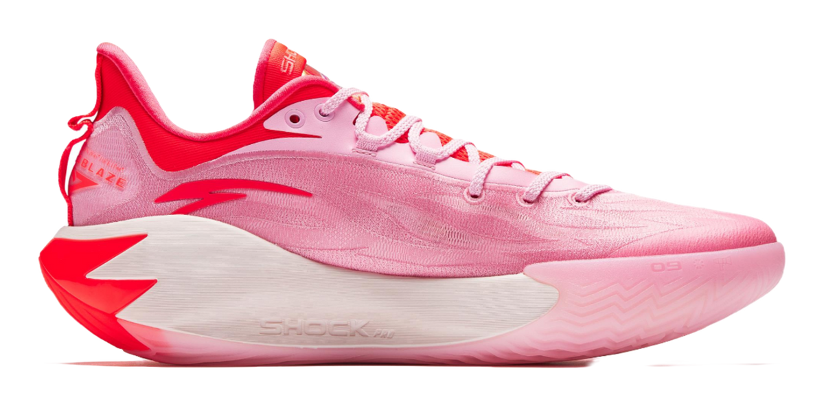 Pink basketball shoe with red trim, lace-up front, and textured midfoot sole