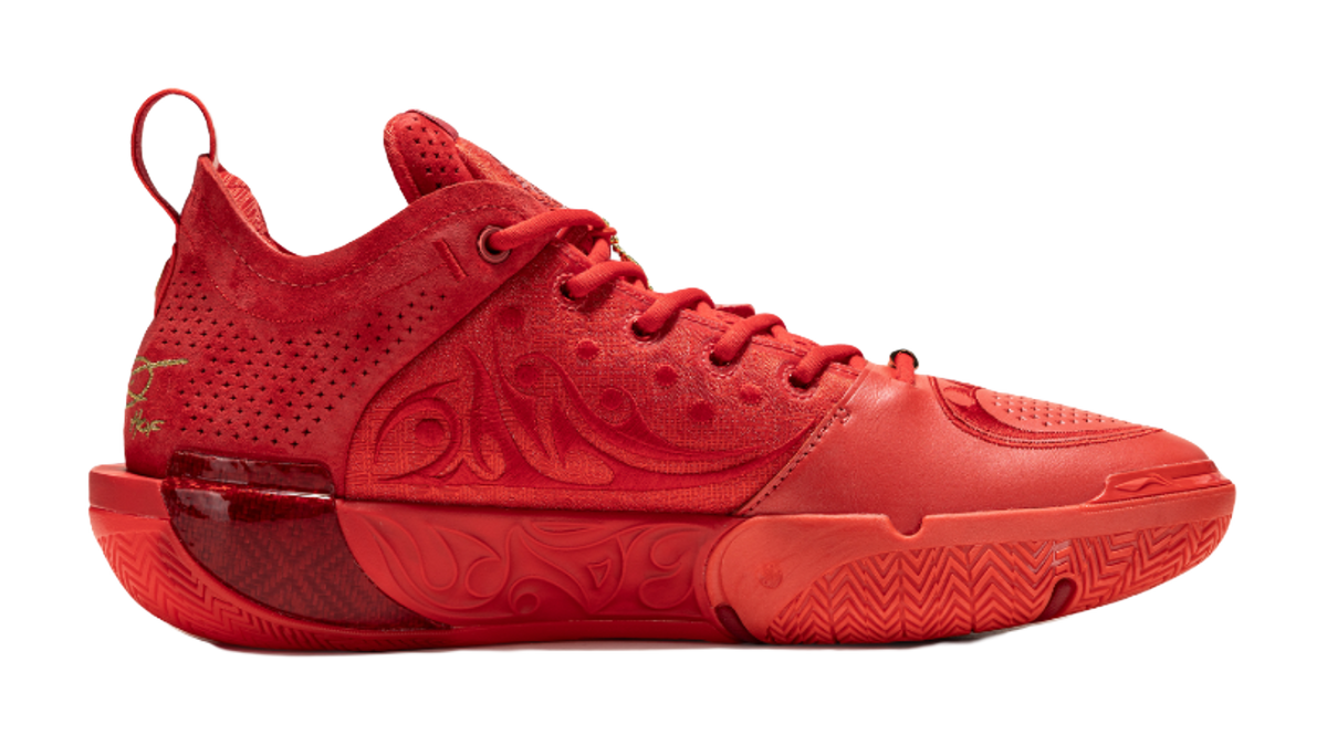 Red lace-up mid-top basketball shoes, side view with textured upper.