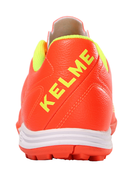 Orange heel and back of TF training soccer shoe with KELME lettering and cushioned collar
