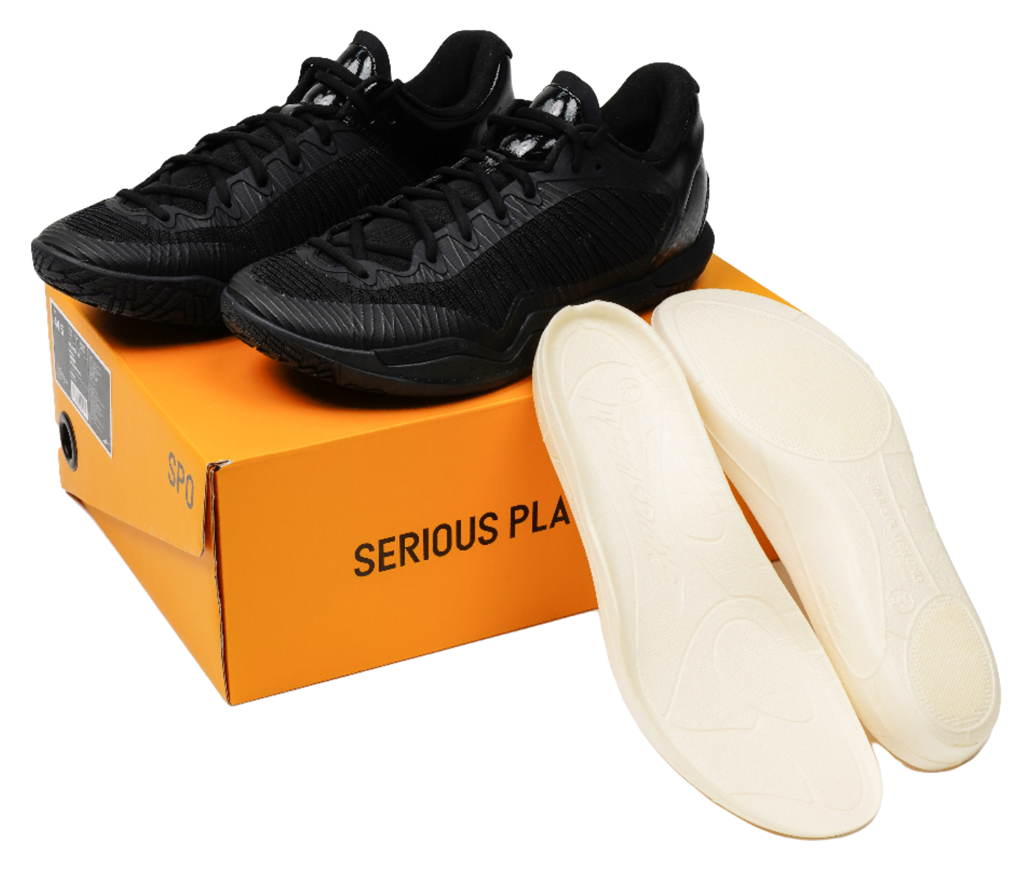 Black low-top basketball shoes with spare light insoles, shown with shoebox.