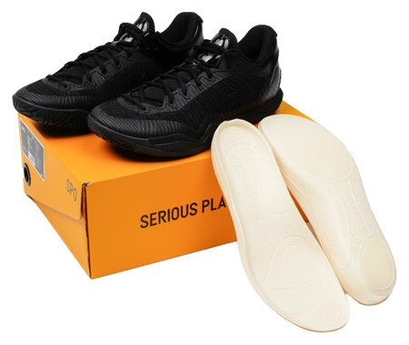 Black low-top basketball shoes with spare light insoles, shown with shoebox.