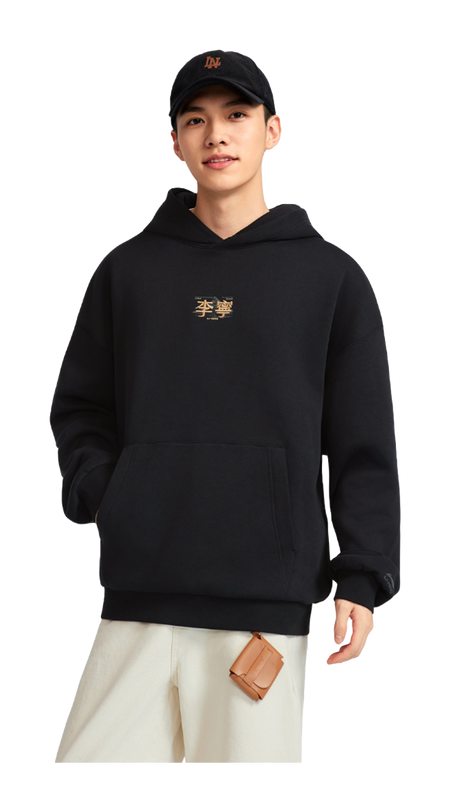 Black hooded fleece-lined pullover worn with light pants